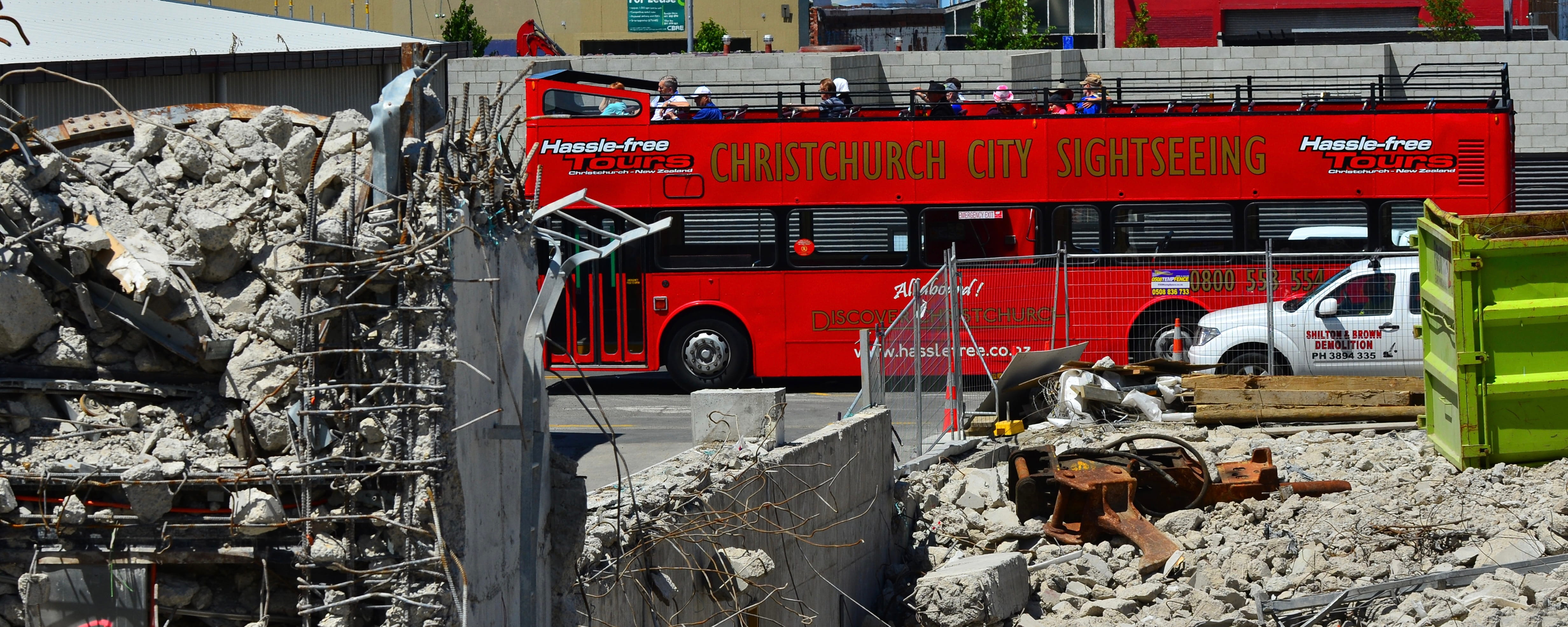 Sightseeing tour bus drives by earthquake destruction in Christchurch