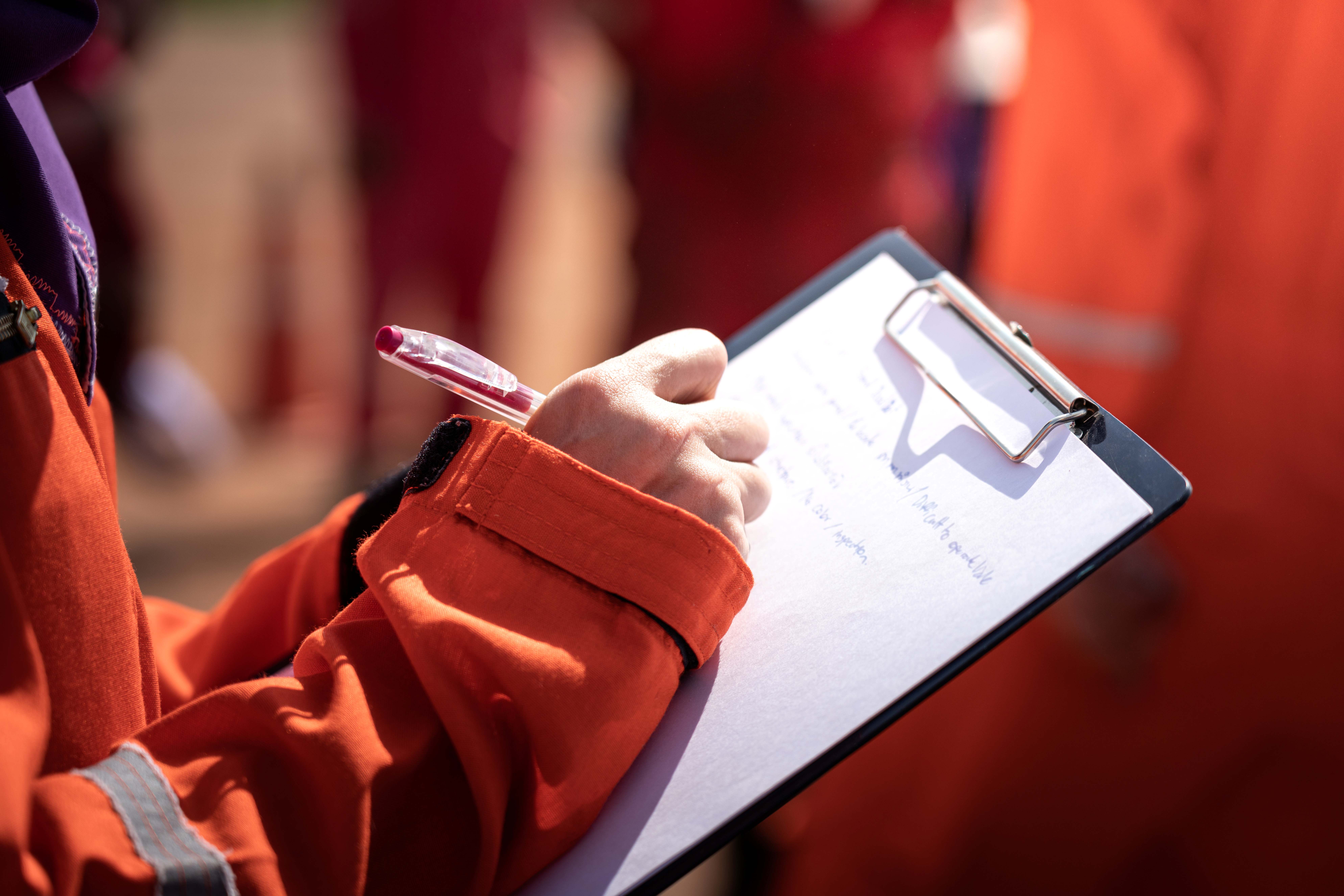 Person taking notes at briefing about oil spill