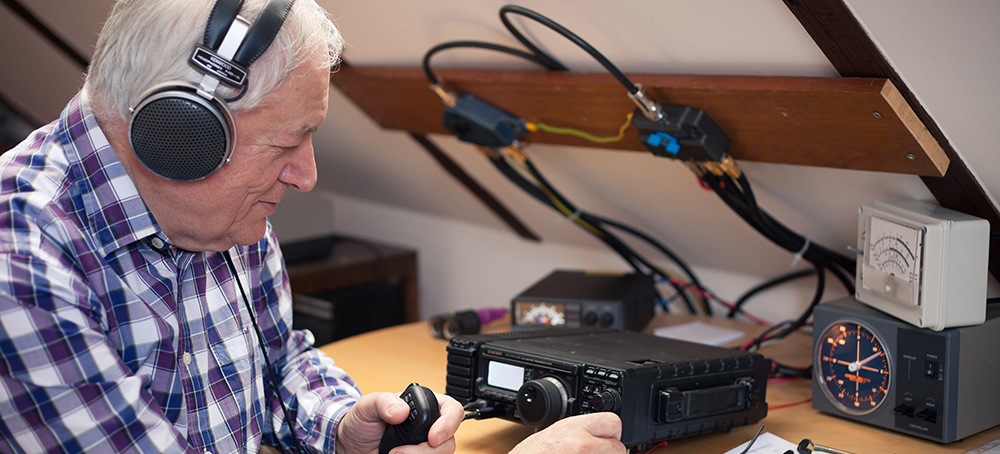 An older man operates a ham radio