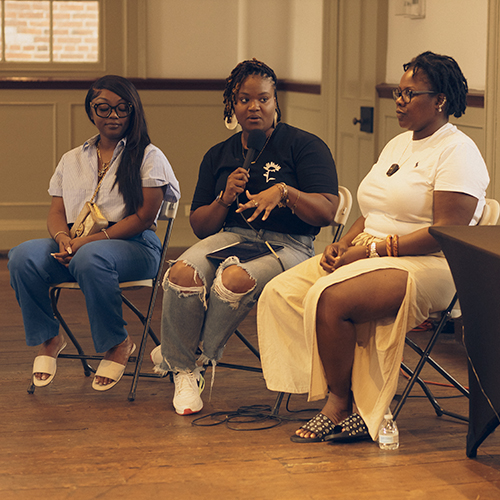 An image of three women conversing on a panel at the I’m Literally Taking it Out of the Mud exhibition at the Delaware Historical Society.