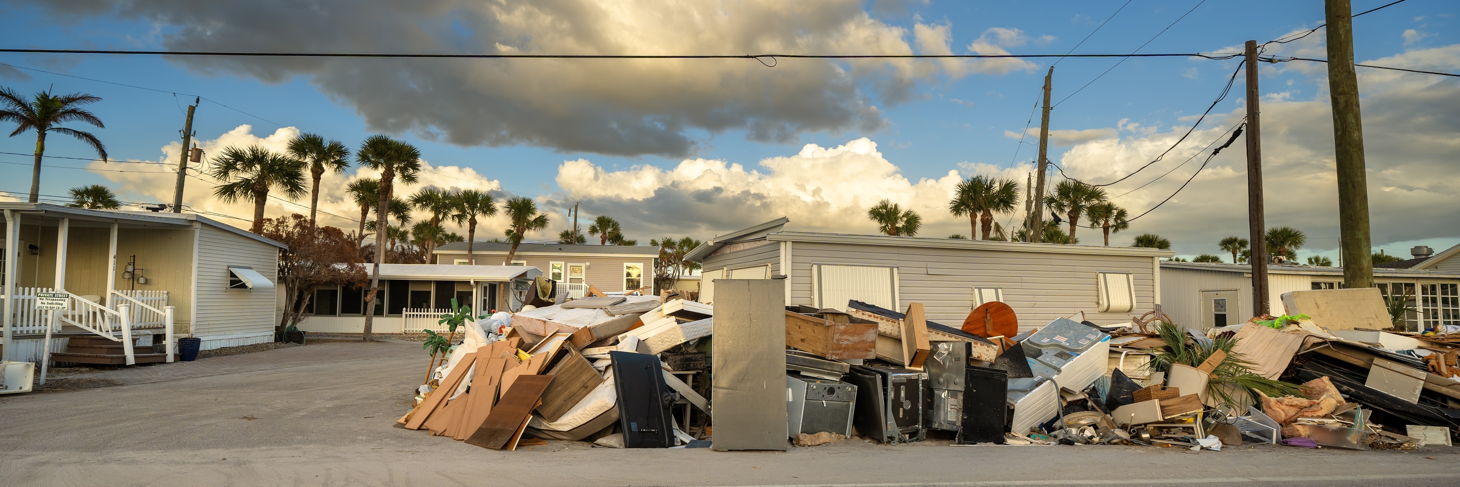 Piles of debris on street side after Hurricane Milton on Manasota Key road in Florida.